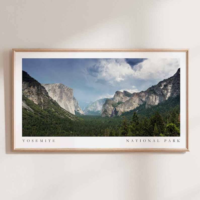May include: A panoramic view of Yosemite National Park, showcasing towering granite cliffs, lush green forests, and a valley with a river winding through it. The sky is partly cloudy, with a hint of blue peeking through the clouds.