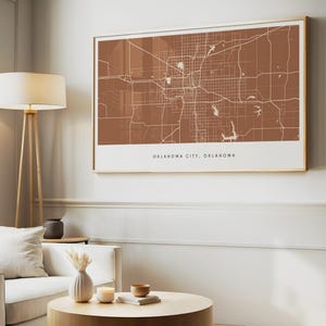 Puede incluir: Un mapa enmarcado de Oklahoma City, Oklahoma, en una combinación de colores marrón cálido y blanco. El mapa es detallado, mostrando calles y puntos de referencia. El marco es dorado y la obra de arte se exhibe en un salón.