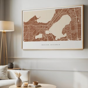 Puede incluir: Una impresión enmarcada de un mapa de Madison, Wisconsin, en un estilo minimalista. El mapa presenta un diseño detallado de la ciudad con una combinación de colores de dos tonos marrón y beige. El texto "MADISON, WISCONSIN" está impreso en la parte inferior.
