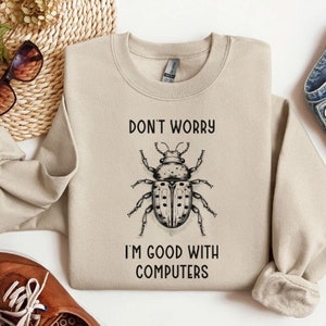 May include: Beige sweatshirt with a black and white illustration of a beetle and the text "Don't worry I'm good with computers".