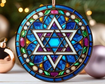 May include: A round, blue glass ornament with a stained glass design of a Star of David. The star is white with a blue center and is surrounded by a colorful border of green, yellow, red, and purple.