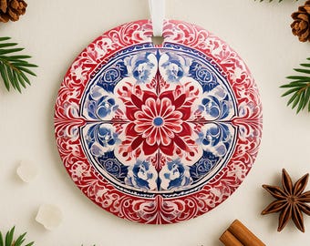 May include: Round red, white, and blue Christmas ornament with a floral pattern. The ornament has a white string for hanging.
