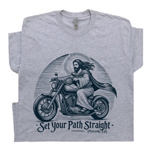 Puede incluir: Una camiseta gris con un gr&aacute;fico de Jes&uacute;s conduciendo una motocicleta. El gr&aacute;fico es de estilo vintage e incluye el texto "Set Your Path Straight - (Proverbs 3:6)"