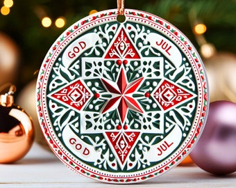 Puede incluir: Un adorno navideño blanco, verde y rojo con un diseño de estrella y las palabras "God Jul" repetidas dos veces.