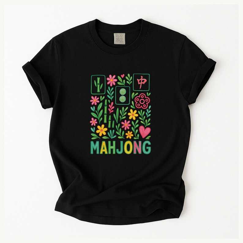 May include: Black t-shirt featuring a colorful floral and bamboo design with the word "MAHJONG" in a rainbow gradient. The design includes Chinese characters and a pink heart.