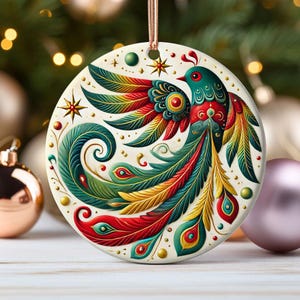 May include: A round ceramic ornament featuring a colorful stylized bird with green, red, yellow, and gold feathers. The bird is surrounded by a white background with small gold and green dots.