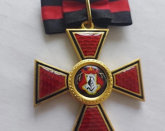 Könnte beinhalten: Eine goldfarbene, kreuzförmige Medaille mit roten und schwarzen Emaille-Details. Die Mitte zeigt ein rundes Emblem mit Wappen. Die Medaille ist an einem schwarz-roten Band befestigt.