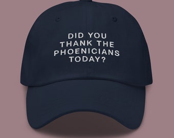 Könnte beinhalten: Eine marineblaue Baseballkappe mit weiß gesticktem Text, der lautet: "Hast du dich heute bei den Phöniziern bedankt?"