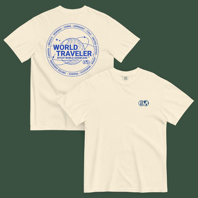 May include: Two cream-colored t-shirts. One shirt features a blue circular design with the text "WORLD TRAVELER" and "EPCOT WORLD SHOWCASE". The other shirt has a small blue globe design with "1982".