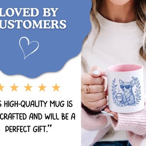 May include: White ceramic mug with a pink interior, featuring a blue illustration of a chihuahua wearing sunglasses and holding a coffee cup. The mug is held by a person. The text "LOVED BY CUSTOMERS" is at the top.