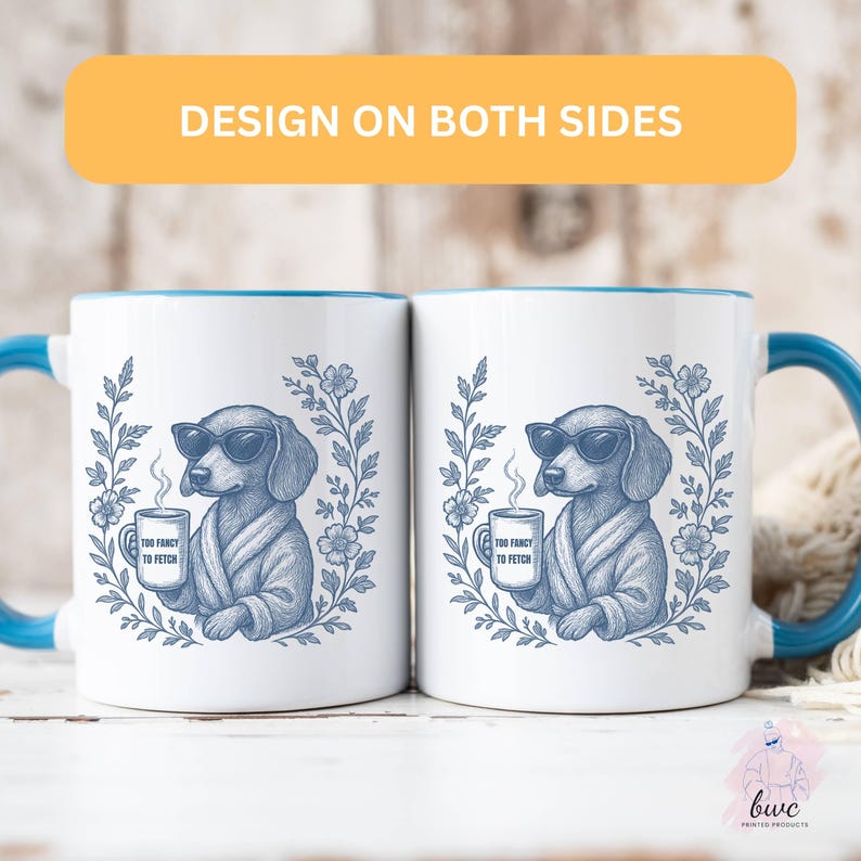 May include: Two white ceramic mugs with blue handles and rims. Each mug features a blue illustration of a dog wearing sunglasses and a robe, holding a mug that says "Too Fancy to Fetch". The text "Design on Both Sides" is above the mugs.