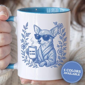 May include: White ceramic mug with a blue interior and handle. The mug features a blue illustration of a chihuahua wearing sunglasses and a robe, holding a mug with the text "Too Fancy to Fetch". Decorative floral elements surround the dog.