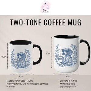 May include: Two-tone coffee mugs with a black handle and interior. The white exterior features a blue illustration of a dog wearing sunglasses and a robe, holding a mug. The text "TOO FANCY TO FETCH" is on the mug. The mugs are 3.78" and 4.76" tall.