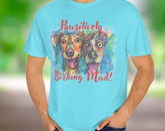May include: A light blue t-shirt with a colorful illustration of two dogs with the text "Pawsitively Barking Mad!" printed on the front.