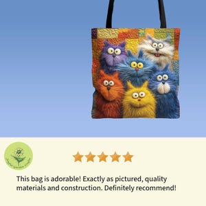 May include: A tote bag featuring a colorful, cartoonish design of six fluffy cats in various colors. The cats have large eyes and expressive faces. The bag has black handles and a blue background.