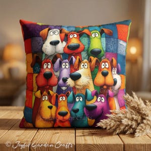 Puede incluir: Un cojín cuadrado con un fondo de patchwork colorido y un grupo de perros de dibujos animados en varios tonos de rojo, naranja, amarillo, verde, azul y morado. Cada perro tiene ojos grandes y una nariz negra. El texto Joyful Garden Crafts es visible.
