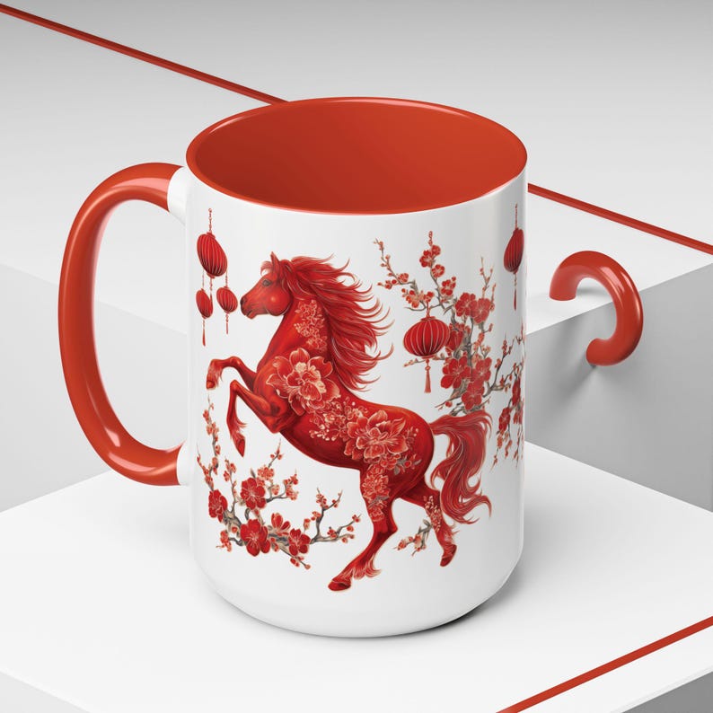 May include: A white ceramic mug with a red interior and handle. The mug features a red horse design with floral accents and hanging lanterns, set against a white background. The design is inspired by Asian art.