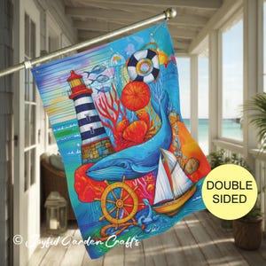 May include: Double-sided nautical garden flag featuring a vibrant ocean scene. The design includes a lighthouse, whale, sailboat, and marine life in shades of blue, orange, and red. The flag is hanging on a metal pole.