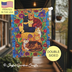 May include: A colorful garden flag featuring a group of cats with different colored fur, surrounded by flowers and leaves. The flag is double-sided and printed in the USA.