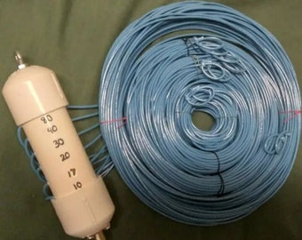 May include: A white plastic antenna tuner with a numbered scale from 10 to 80. The tuner is connected to a coil of blue wire.