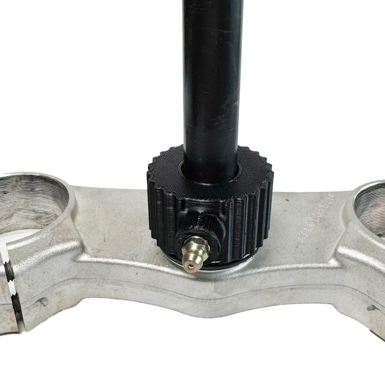 Puede incluir: Una herramienta de instalaci&oacute;n de sello de horquilla negra para motocicletas. La herramienta presenta un eje roscado y un anillo de pl&aacute;stico negro con un peque&ntilde;o accesorio de metal.