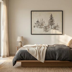 Puede incluir: Dormitorio con cama baja de madera, edredón gris oscuro y manta beige. Una obra de arte en blanco y negro enmarcada de pinos cuelga sobre la cama. Cortinas beige y alfombra de yute completan la paleta de colores neutros.