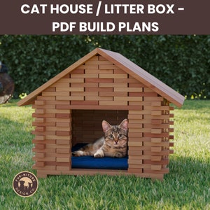 May include: A wooden cat house with a brown roof and a blue cat bed inside. The house is made of stacked wooden planks and has a small opening for the cat to enter. The house is sitting on a green grassy lawn.