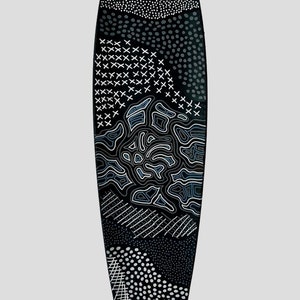 May include: A black surfboard with a white and blue abstract design. The design features various patterns including dots, lines, and crosses.