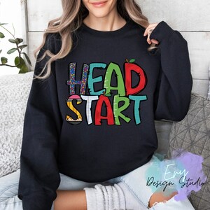 May include: Black sweatshirt with the text "HEAD START" in colorful letters with a pencil, ruler, and apple graphic.