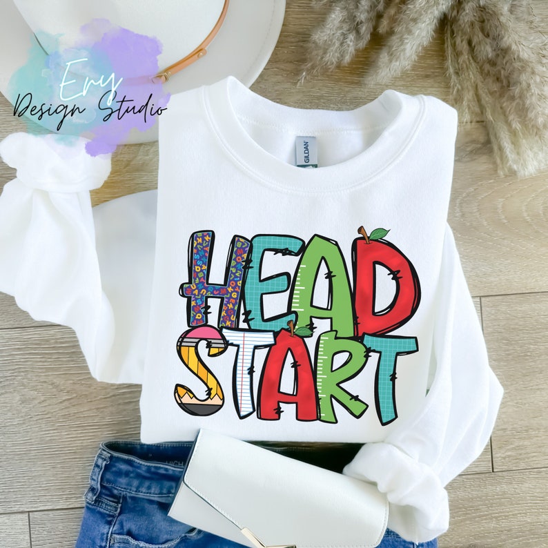 May include: White sweatshirt with the words "HEAD START" in colorful, playful letters. The letters are decorated with school-themed patterns like pencils, apples, and numbers.