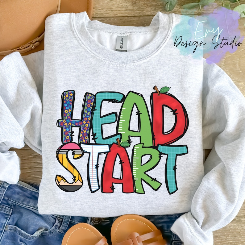 May include: A gray sweatshirt with the words "Head Start" in colorful letters. The letters are decorated with images of pencils, rulers, and apples.