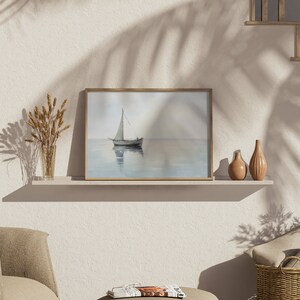 May include: A framed painting of a sailboat on a calm body of water with a light blue sky and a light brown wooden frame.