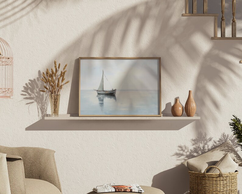 May include: A framed painting of a sailboat on a calm body of water with a light blue sky and a light brown wooden frame.