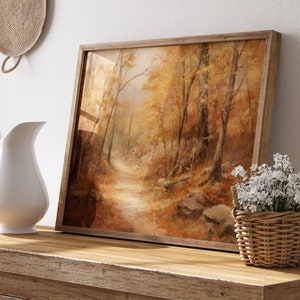 May include: A framed painting of a forest path with autumn leaves in shades of yellow, orange, and brown. The path leads into the distance, surrounded by trees.