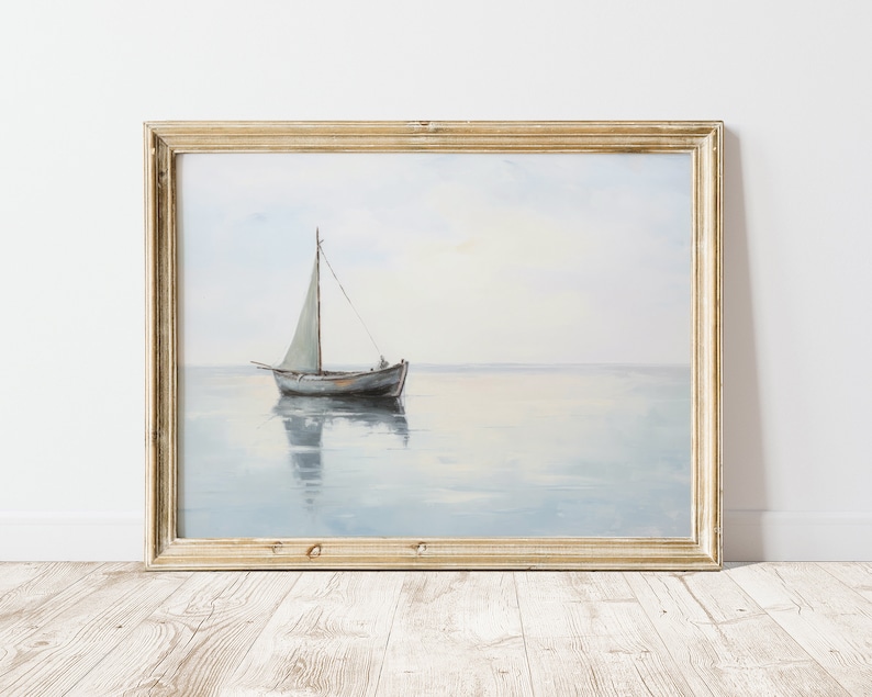 May include: A framed painting depicting a sailboat on a calm, blue sea. The sailboat has a white sail and is sailing towards the horizon. The painting is in a light wood frame.