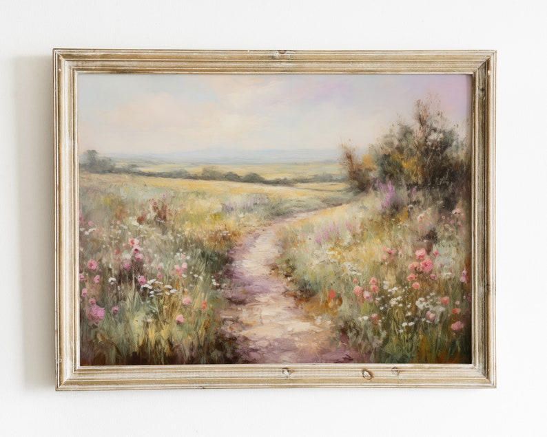 May include: A framed oil painting depicting a winding dirt path through a field of wildflowers. The path leads to a distant horizon with a blue sky and fluffy clouds. The painting is in a light wood frame.