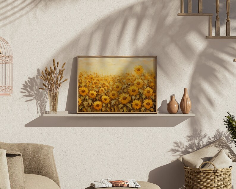 May include: A framed painting of a field of sunflowers in shades of yellow and brown. The painting is on a shelf with a vase of dried wheat and two decorative vases.