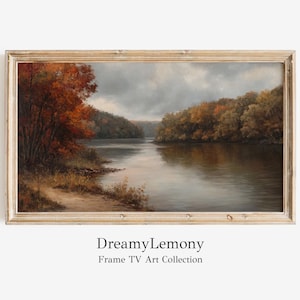 Può includere: Un dipinto incorniciato che rappresenta una scena fluviale con fogliame autunnale. Il fiume è calmo e riflettente, con alberi che costeggiano le sue rive. Il cielo è nuvoloso e grigio, con sfumature di blu. Il dipinto è in una cornice di legno chiaro.