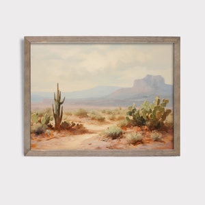 May include: A framed painting of a desert landscape with a tall cactus and smaller cacti in the foreground. The background features a mountain range and a cloudy sky.