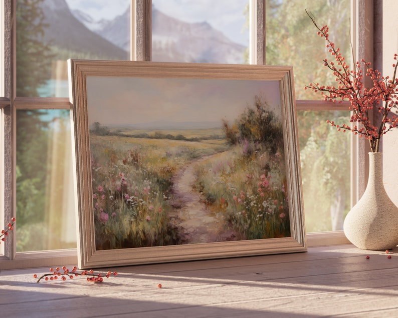 May include: A framed painting of a landscape with a dirt path leading through a field of wildflowers. The painting is in a light wood frame and is hanging on a wall.