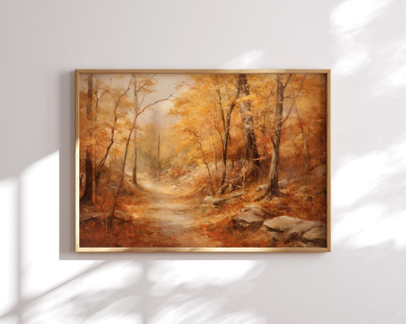 May include: A painting of a forest path in autumn. The trees are mostly bare, but some have yellow leaves. The path is lined with rocks and fallen leaves. The painting is in a wooden frame.