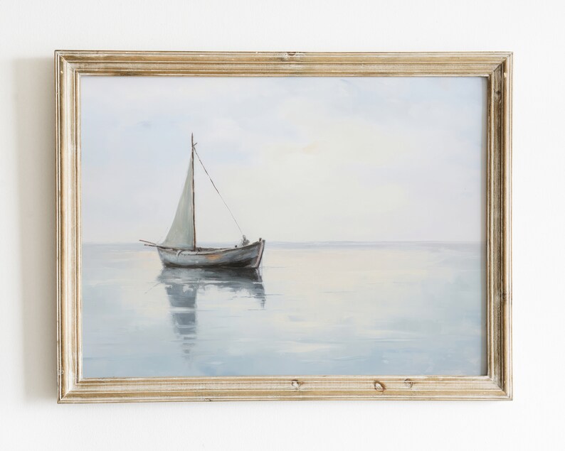 May include: A framed painting depicting a sailboat on a tranquil, blue expanse of water. The sailboat features a white sail and is positioned centrally in the image. The sky is a pale blue, while the water is a light blue with a subtle hint of grey.