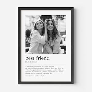 May include: Framed black and white print with a photograph of two women smiling. The print includes the words "best friend" and a definition. The women are wearing light-coloured shirts.