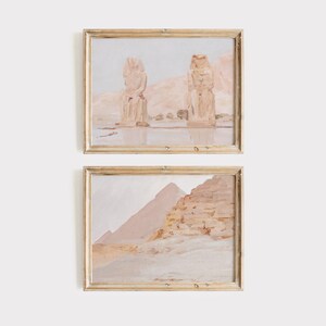 Puede incluir: Dos pinturas enmarcadas que representan paisajes des&eacute;rticos en tonos apagados. La pintura superior muestra dos grandes estatuas en un entorno des&eacute;rtico, mientras que la pintura inferior muestra una pir&aacute;mide y el desierto circundante.