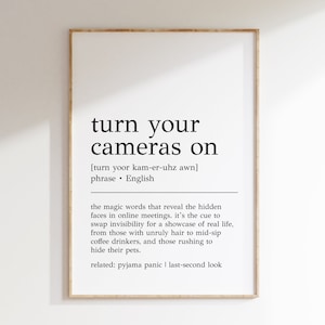 May include: Black and white printable wall art with the definition of the phrase "turn your cameras on". The definition describes the phrase as the magic words that reveal the hidden faces in online meetings. It also lists related phrases: "pyjama panic" and "last-second look".