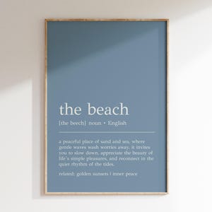 Könnte beinhalten: Ein blauer, druckbarer Wandkunstdruck mit dem Wort "the beach" in weißer Schrift und einer Definition des Wortes. Die Definition lautet: "[the beech] Substantiv. Englisch ein friedlicher Ort aus Sand und Meer, an dem sanfte Wellen die Sorgen wegspülen, er lädt dich ein, langsamer zu werden, die Schönheit der einfachen Freuden des Lebens zu schätzen und dich im ruhigen Rhythmus der Gezeiten wieder zu verbinden. verwandt: goldene Sonnenuntergänge | innerer Frieden"