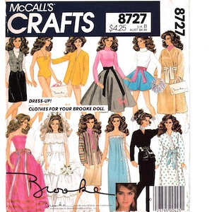 May include: A vintage McCall's Crafts sewing pattern for making clothes for a Brooke doll. The pattern includes 10 different outfits, including a wedding dress, a swimsuit, a skirt and top, a coat, and a nightgown. The pattern number is 8727.