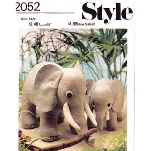 Pode incluir: Um padrão de costura vintage para fazer dois brinquedos de pelúcia de elefante. O padrão é intitulado "Style" e tem o número 2052 impresso nele. O padrão mostra um elefante maior com um elefante menor ao lado.