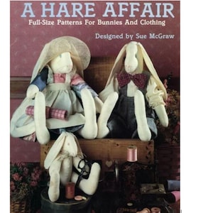Könnte beinhalten: Das Buchcover zeigt den Titel "A HARE AFFAIR" mit dem Untertitel "Full-Size Patterns For Bunnies And Clothing" und den Namen des Designers. Das Bild zeigt drei handgefertigte Hasenpuppen in Vintage-Kleidung, eine davon mit Hut.