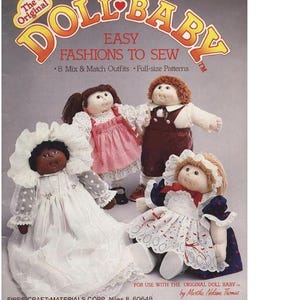 May include: A book cover featuring the title "The Original Doll Baby Easy Fashions to Sew" with a picture of four dolls wearing different outfits. The book includes eight mix and match outfits and full-size patterns.